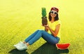 Summer portrait of happy smiling young woman with pineapple and fresh juicy slice of watermelon on the grass in the summer park Royalty Free Stock Photo