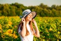Summer portrait of happy young woman in hat with long hair in sunflower field Royalty Free Stock Photo