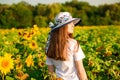 Summer portrait of happy young woman in hat with long hair in sunflower field Royalty Free Stock Photo