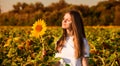 Summer portrait of happy young woman in hat with long hair in sunflower field Royalty Free Stock Photo