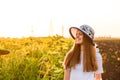 Summer portrait of happy young woman in hat with long hair in sunflower field Royalty Free Stock Photo