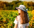 Summer portrait of happy young woman in hat with long hair in sunflower field Royalty Free Stock Photo