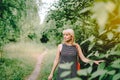 Summer portrait of mature adult blonde woman near the trees on sunny day in the park. Royalty Free Stock Photo