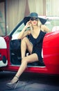 Summer portrait of stylish blonde vintage woman with long legs posing near red retro car. Fashionable attractive fair hair female Royalty Free Stock Photo