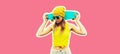 Summer portrait of stylish cool young woman with skateboard wearing colorful clothes on pink background, magazine style Royalty Free Stock Photo