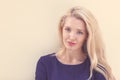 Summer portrait of young beautiful blond woman in blue dress posing near the wall and have fun. Toned in warm colors Royalty Free Stock Photo