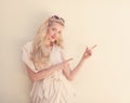 Summer portrait of young beautiful blond woman in white dress posing near the wall and have fun. Toned in warm colors Royalty Free Stock Photo