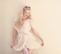 Summer portrait of young beautiful blond woman in white dress posing near the wall and have fun. Toned in warm colors Royalty Free Stock Photo