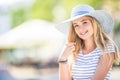 Summer portrait of young beautiful woman in hat sitting on bench in park Royalty Free Stock Photo