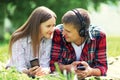 Summer portrait young couple lying relaxing on grass listens to music in headphones on smartphone Royalty Free Stock Photo