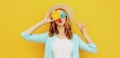 Summer portrait of young woman covering her eyes with fruits slice of orange blowing red lips Royalty Free Stock Photo