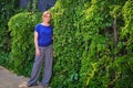 Summer portrait of a young woman with glasses, copy space. Happy woman in a summer day near the ivy. Girl face on a background of Royalty Free Stock Photo