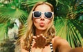 Summer portrait of young woman stretching her hand for taking selfie with smartphone blowing her lips sending sweet air kiss on Royalty Free Stock Photo