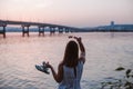 summer postcard, a young woman stands with her back, holding sunglasses and beach flip-flops admiring the sunset, the Royalty Free Stock Photo