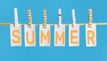 Summer poster with lettering summer, inscription on white pieces of paper hanging with clothespins