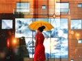 summer rain city woman with umbrella walk on street big building windows vitrines blurred light ,urban lifestyle Royalty Free Stock Photo