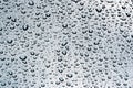 Summer rain, drops of water on the car paint. a small round or pear-shaped portion of liquid that hangs or falls or adheres to a Royalty Free Stock Photo