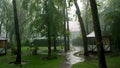 summer rain, a thunderstorm, a heavy downpour at the recreation center, in a pine forest, park. water flows down in Royalty Free Stock Photo