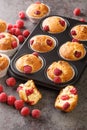 Summer raspberry muffins with white chocolate close-up in a muffin pan. Vertical Royalty Free Stock Photo