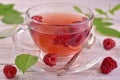Summer raspberry tea in a transparent cup, vintage wooden background.Close-up.