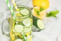 Summer refreshing cocktail with cucumber, lemon, mint and ice in mason jar on a white wooden background. Royalty Free Stock Photo