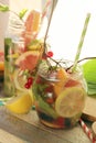 Summer refreshing cocktail, detox water from organic fruits and berries, mint leaves in glass jugs
