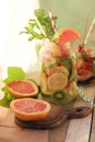 Summer refreshing cocktail, detox water from organic fruits and berries, mint leaves in glass jugs