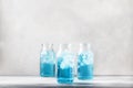 Summer refreshing cold drink, isotonic blue water in bottles, gray table background, selective focus Royalty Free Stock Photo