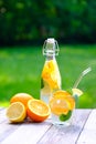 Summer refreshing detox cocktail with lemon slices, orange and mint on wooden table. Cold homemade lemonade, citrus cocktail Royalty Free Stock Photo