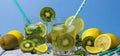 Summer refreshing drink in glasses with a straw. Cold sweet and sour lemonade with lemon, kiwi, mint and ice cubes Royalty Free Stock Photo