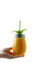 Summer refreshing drink, juice or cocktail. Woman's hand holding pineapple mason jar filled with orange juice, isolated, copy