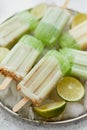 Summer refreshing homemade lime popsicles with chipped ice over stone background