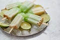 Summer refreshing homemade lime popsicles with chipped ice over stone background