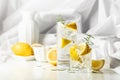 Summer refreshing lemonade drink or alcoholic cocktail with ice, rosemary and lemon slices on the white table Royalty Free Stock Photo