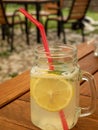 Summer refreshing mojito lemonade in glass jar mug with slice of lemon, ice, red straw and mint Royalty Free Stock Photo