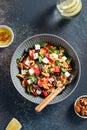 Summer refreshing salad with watermelon, feta cheese, walnuts and greens on black table top with lemon water, vertical image, top Royalty Free Stock Photo