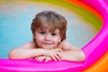 Summer relaxation in the pool. A child lies and relax in a home pool with a smile. Summer rest. Vacations. Cute baby Royalty Free Stock Photo