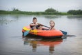 In the summer on the river happy boy with a girl swim in a rubber inflatable boat Royalty Free Stock Photo