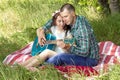 Summer romantic picnic. guy shows the girl how to play the guitar. couple sitting on the grass Royalty Free Stock Photo