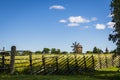 Summer rural landscape, behind a wooden fence an old windmill and a wooden church on the island of Kizhi in Karelia Royalty Free Stock Photo