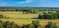 Summer rural landscape with sheafs of hay on agriculture fields and forest