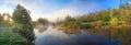Rural panorama with river, fog and forest at sunrise Royalty Free Stock Photo