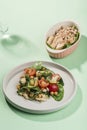 Summer salad of chicken and fresh vegetables: cucumber, cherry tomato, corn and spinach on a green background with reflections and