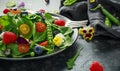 Summer salad with edible flowers, spinach, blueberries, raspberry, sweet peas, cherry tomatos and feta cheese Royalty Free Stock Photo