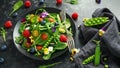 Summer salad with edible flowers, spinach, blueberries, raspberry, sweet peas, cherry tomatos and feta cheese Royalty Free Stock Photo