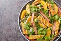 Summer salad of fried chicken, rhubarb, lettuce, onions and oranges close-up on a plate. horizontal top view Royalty Free Stock Photo