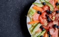 Summer salad with salmon, carrots, tomatoes, avocado, ginger, blueberries, goji berries, fresh vegetables and seeds