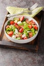 Summer salad of strawberries, avocado, bacon, lettuce, goat cheese close-up in a bowl. Vertical Royalty Free Stock Photo