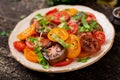 Summer salad of tomatoes of different colors with green herbs Royalty Free Stock Photo