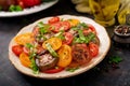 Summer salad of tomatoes of different colors with green herbs Royalty Free Stock Photo